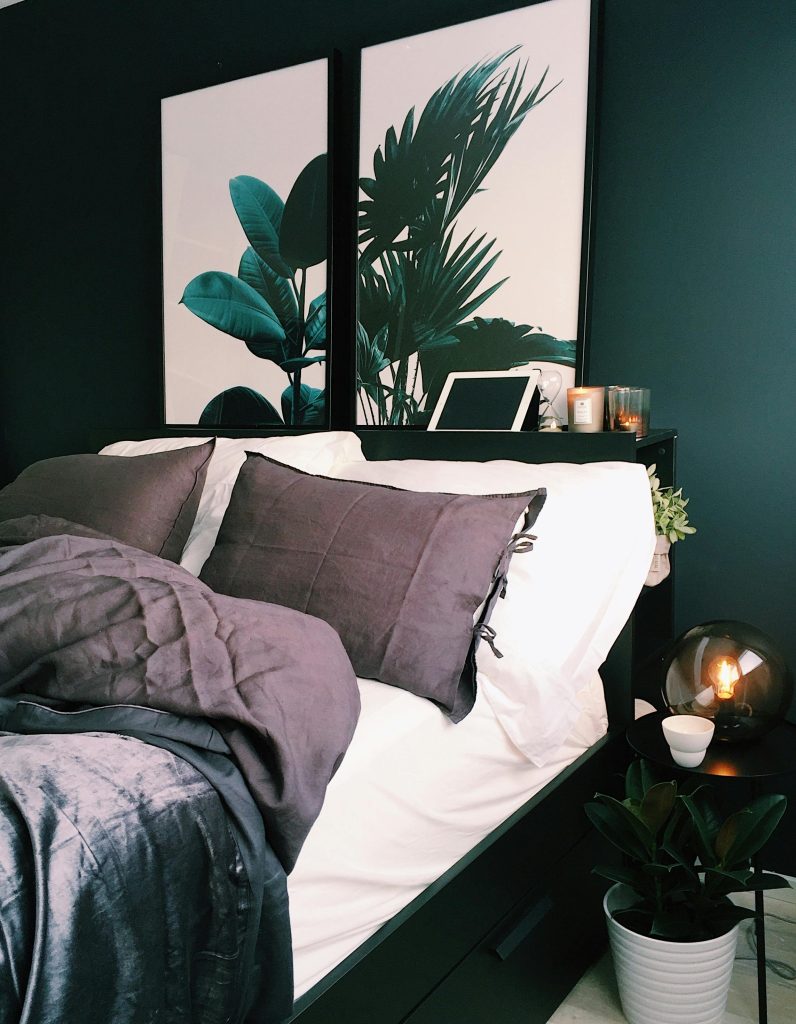 img-01-free-img A stylish and cozy bedroom featuring green walls, botanical prints, and soft lighting for a contemporary feel.