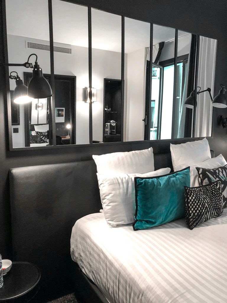 Chambre Stylish bedroom featuring modern decor, plush pillows, and large mirrors enhancing the space.