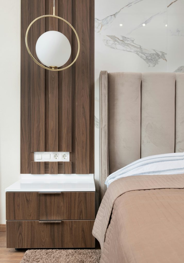 Chambre Interior of modern hotel room with bed next to bedside table under lamp hanging from ceiling